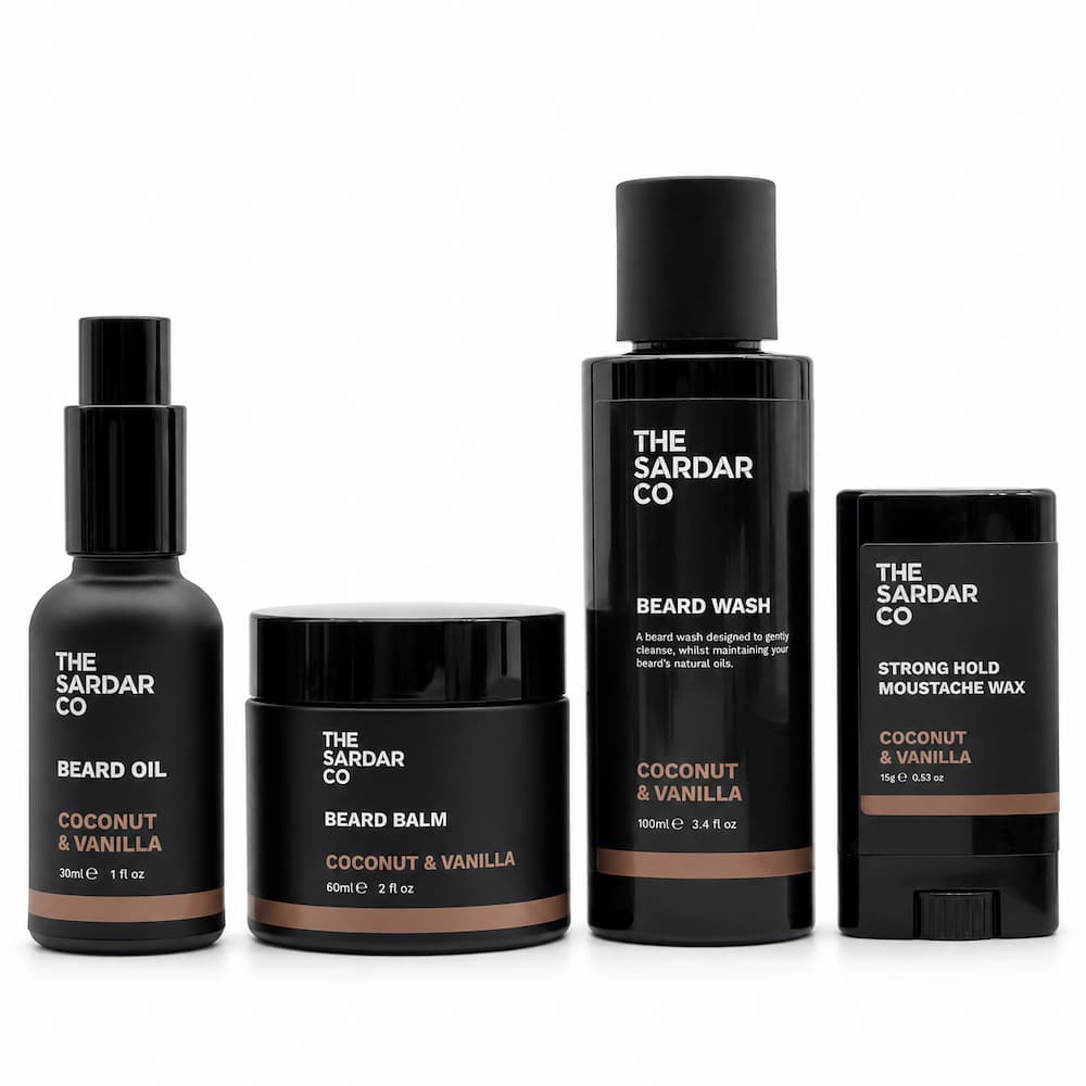 Four beard grooming products from The Sardar Co in a coconut and vanilla scent, including beard oil, beard balm, beard wash, and strong hold moustache wax, arranged on a white background.