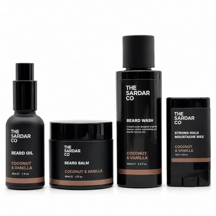 Four beard grooming products from The Sardar Co in a coconut and vanilla scent, including beard oil, beard balm, beard wash, and strong hold moustache wax, arranged on a white background.