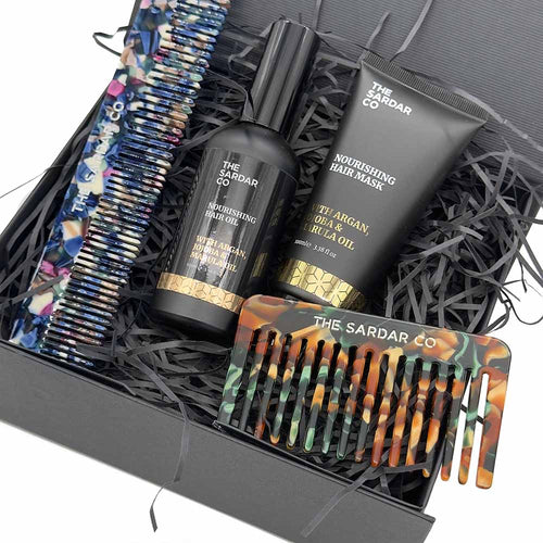 close up of hair care gift products inside the gift box with shredded paper