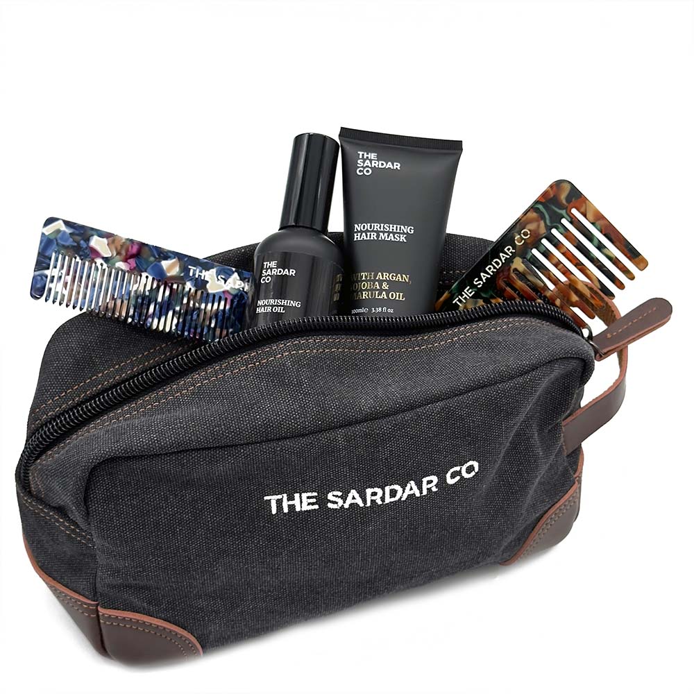 Black toiletry bag with 'The Sardar Co' branding, containing hair care products and combs.