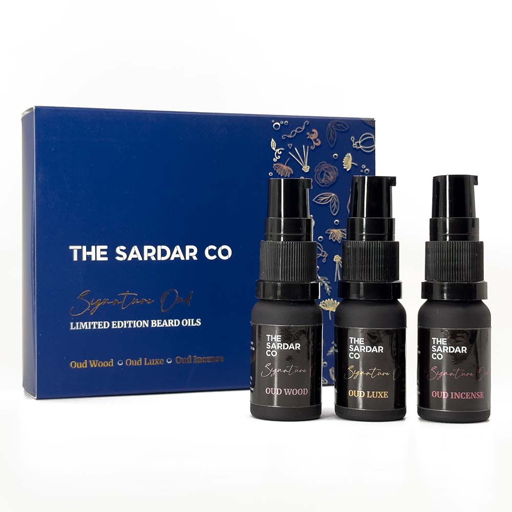 Three black signature oud beard oil bottles in front of packaging