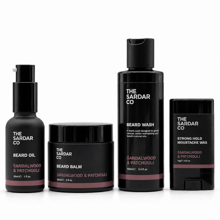 Four black beard grooming products from The Sardar Co on a white background: beard oil, beard balm, beard wash, and strong hold moussantache wax.