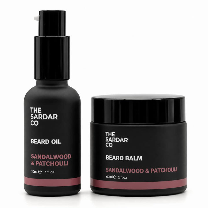 The Sardar Co Beard Oil and Beard Balm set in matte black bottles and jars with white and dusty rose lettering, on a clean white background.