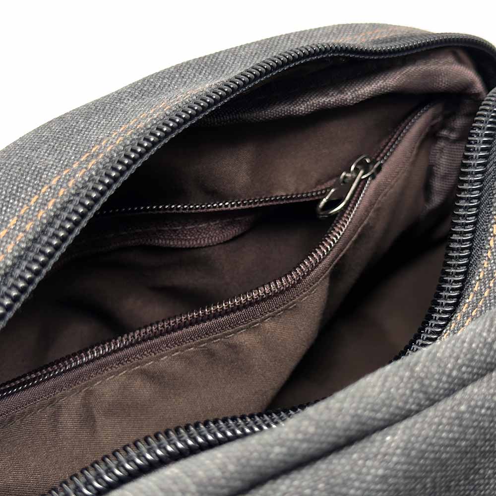 Close-up of a gray bag with a zipper, showing the interior.