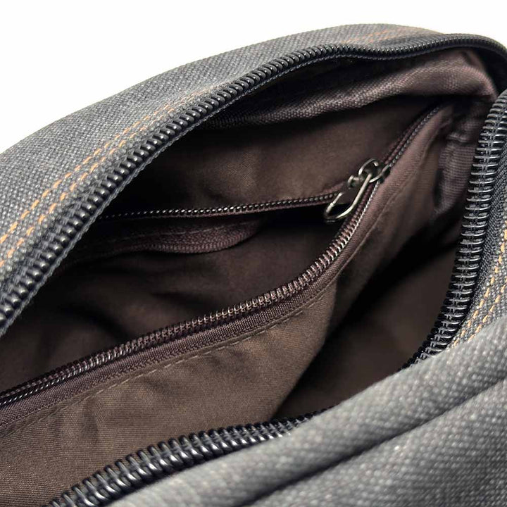 Close-up of a gray bag with a zipper, showing the interior.
