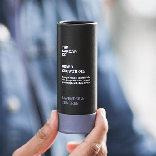 man holding lavender and tea tree beard oil tube